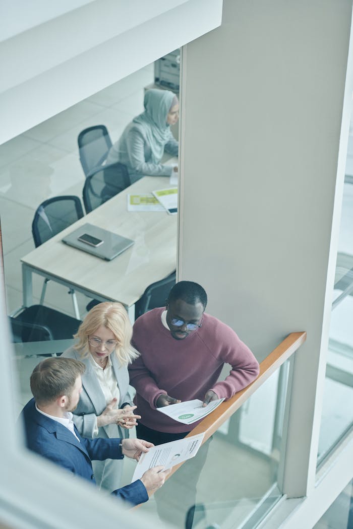 Business team discussing documents in a bright, modern office setting.